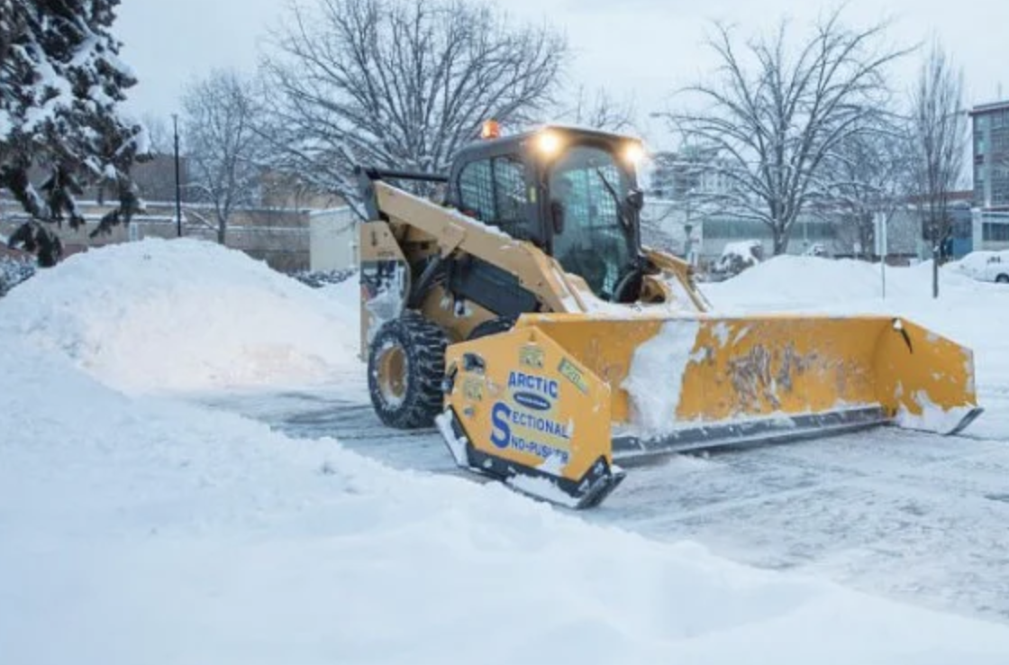 Going Yard skid steer clearing a commercial parking lot in Edmonton